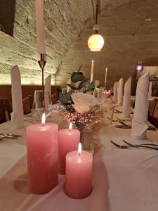 Ein Tisch mit rosa Kerzen auf einer weißen Tischdecke in der Unterkunft HeiMaT Häusle - Heike Marcus Tiny-houses in Cleebronn