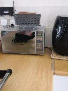 a microwave sitting on a counter with a basket on top at Duplex in Tableview in Cape Town