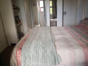 a bedroom with a bed with a comforter on it at Duplex in Tableview in Cape Town