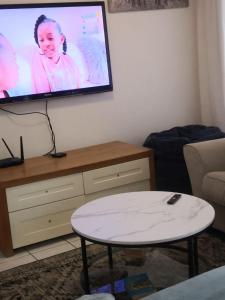 a living room with a flat screen tv on the wall at Duplex in Tableview in Cape Town