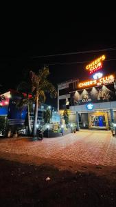 ein Gebäude mit Palmen in der Nacht davor in der Unterkunft Cheers Club & Hotel in Udaipur