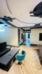 ein Wohnzimmer mit einem blauen Stuhl und einem Tisch in der Unterkunft Cheers Club & Hotel in Udaipur