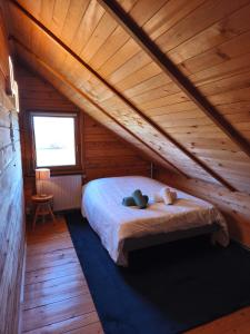 een slaapkamer met een bed in een houten hut bij Holzhaus in Langatte