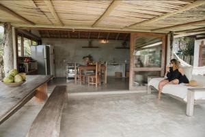 a woman sitting on a couch in a living room at Canto do Mar Caraiva in Caraíva +19 photos