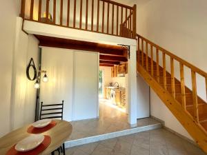 ein Esszimmer mit einem Tisch und einer Treppe in der Unterkunft Charmant Duplex à la campagne in Riventosa