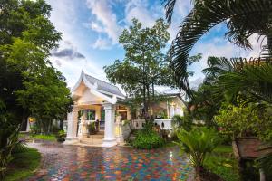 uma villa com jardim atropical e uma entrada em E-outfitting Boutique Chiang Mai em Chiang Mai