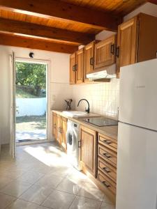 eine Küche mit einem weißen Kühlschrank und einem Geschirrspüler in der Unterkunft Charmant Duplex à la campagne in Riventosa