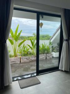 Habitación con ventana grande con vistas al océano. en Anchie Retreat Villa Hội An, en An Bàn (2)