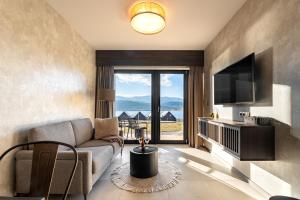 a living room with a couch and a tv at Apartament Lake&Hill View w Karkonoszach z możliwym dostępem do strefy WELLNESS w kompleksie in Sosnówka