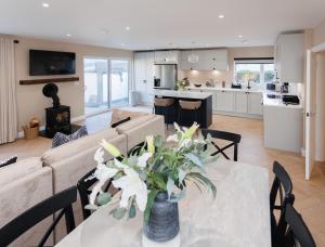 a living room with a couch and a table with flowers at The Views Retreat in Newcastle