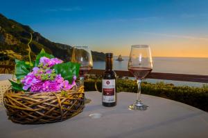 a table with two glasses of wine and a basket of flowers at Sunny views studios in Agios Gordios