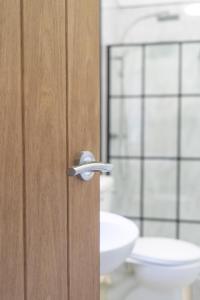 een badkamer met een houten deur en een wastafel bij The Woodrouffee retreat in Carlisle