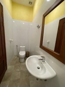 a bathroom with a white sink and a toilet at Maam Guesthouse in Phnom Penh