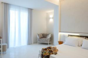 a bedroom with a large bed and a chair at OLIVETO A MARE - Suite & Apartment in Ascea +82 photos