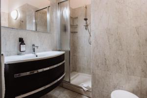 un baño con lavabo y ducha en Hotel Chelsea, en Turín
