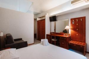 una habitación de hotel con una cama y un escritorio en Hotel Chelsea, en Turín