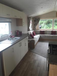 a kitchen and living room with a couch at Lovely 3 Bed Caravan, Milford on Sea in Milford on Sea