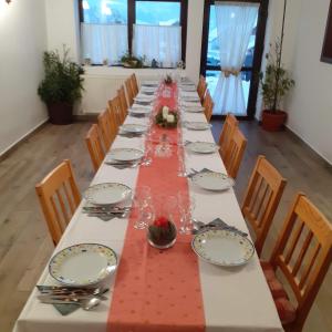 una mesa larga con un mantel rojo y sillas en Vila Puiu Borsa MM, en Borşa