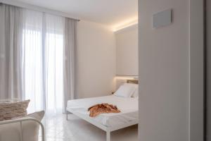 a white bedroom with a bed and a window at OLIVETO A MARE - Suite & Apartment in Ascea