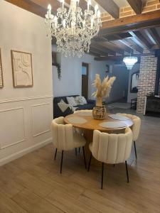 a dining room with a table and chairs and a chandelier at havre de paix a la Sologne in Veilleins +46 photos