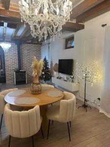 a dining room with a table and chairs and a chandelier at havre de paix a la Sologne in Veilleins
