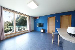 ein Badezimmer mit Waschbecken und großem Fenster in der Unterkunft Gangneung Maison de Rose in Gangneung