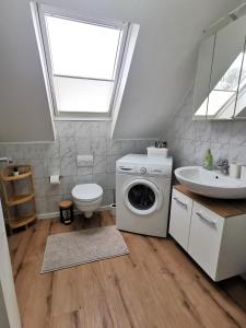 une salle de bains avec lave-linge et lavabo dans l'établissement Ganzes Appartement Nähe Zentrum, à Cobourg