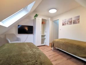 une chambre mansardée avec deux lits et une télévision dans l'établissement Ganzes Appartement Nähe Zentrum, à Cobourg