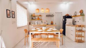 Una cocina con mesa y sillas y un refrigerador. en Halaman Homestay, en Klang