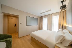 a hotel room with a bed and a tv at MEI DI DU JIA HOTEL in Shanghai