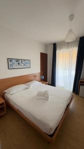 Un dormitorio con una cama grande con dos toallas encima. en Hotel Al Sole, en Grado