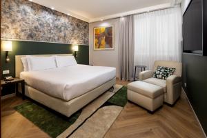 a hotel room with a bed and a chair at Crowne Plaza Padova by IHG in Padova