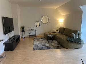 Una sala de estar con un sofá y un televisor. en 2 Zi Wohnung, zentrale Lage mit Parkplatz, 15 min vom Hbf Hamburg, en Pinneberg