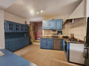 a large kitchen with blue cabinets and appliances at Casa de Emaús - Gerês in Terras de Bouro