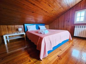 a bedroom with a bed in a wooden room at Casa de Emaús - Gerês in Terras de Bouro