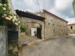 an old stone building with a white door at Casa de Emaús - Gerês in Terras de Bouro +4 photos