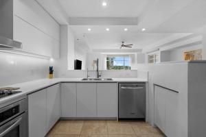 eine weiße Küche mit Spüle und Fenster in der Unterkunft Villa Jasmine Ritz Reserve Plantation residence in Higuillar