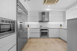 eine Küche mit weißen Schränken und Geräten aus Edelstahl in der Unterkunft Villa Jasmine Ritz Reserve Plantation residence in Higuillar + 51 Fotos