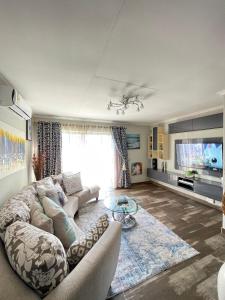 ein Wohnzimmer mit Sofa und Fernseher in der Unterkunft Buenos Manor in Roodepoort