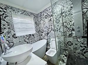 ein schwarz-weißes Badezimmer mit Toilette und Waschbecken in der Unterkunft Buenos Manor in Roodepoort + 46 Fotos