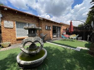 einen Brunnen im Hof eines Hauses in der Unterkunft Buenos Manor in Roodepoort