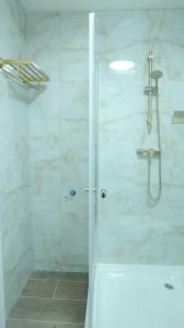 un bagno con doccia con porta in vetro di הצימר של תמר - אורחן מתאים לדתיים a Safed