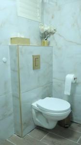 a white bathroom with a toilet and a vase of flowers at הצימר של תמר - יש מקלט פרטי צמוד in Safed +2 photos