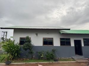 a white house with a green roof at Saensuk stay in Ban Wang Thong
