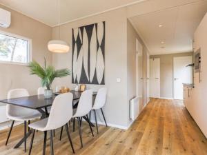a dining room with a black table and white chairs at Casa Leon in Haarle +15 photos