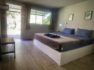 a bedroom with a large bed and a window at Ozone Beach House in Ko Lanta