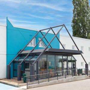 a blue building with a large metal structure at Kyriad ECO - Dijon Sud Chenove in Chenôve