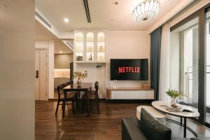 ein Wohnzimmer mit Tisch und Küche in der Unterkunft Hermes Housing- Masteri West Heights in Hanoi