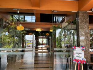 a lobby of a building with glass doors and plants at WYNS Hotel Bandung in Bandung