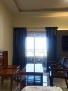 a living room with a large window with blue curtains at VGN Convention Centre in Vāniyambādi